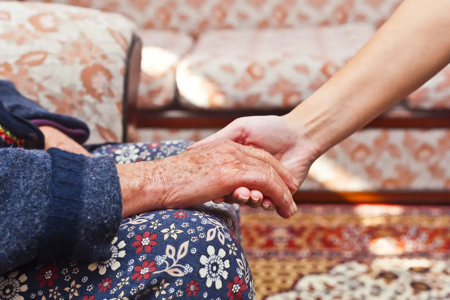 Eine alte Hand und eine junge Hand berühren sich