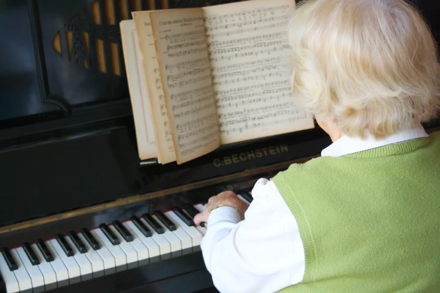 Eine ältere Frau spielt Klavier