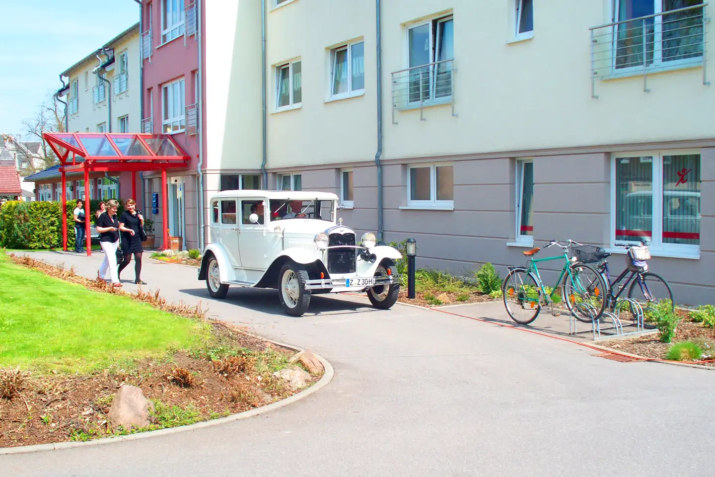 Ein weißer Oldtimer verlässt den Hof