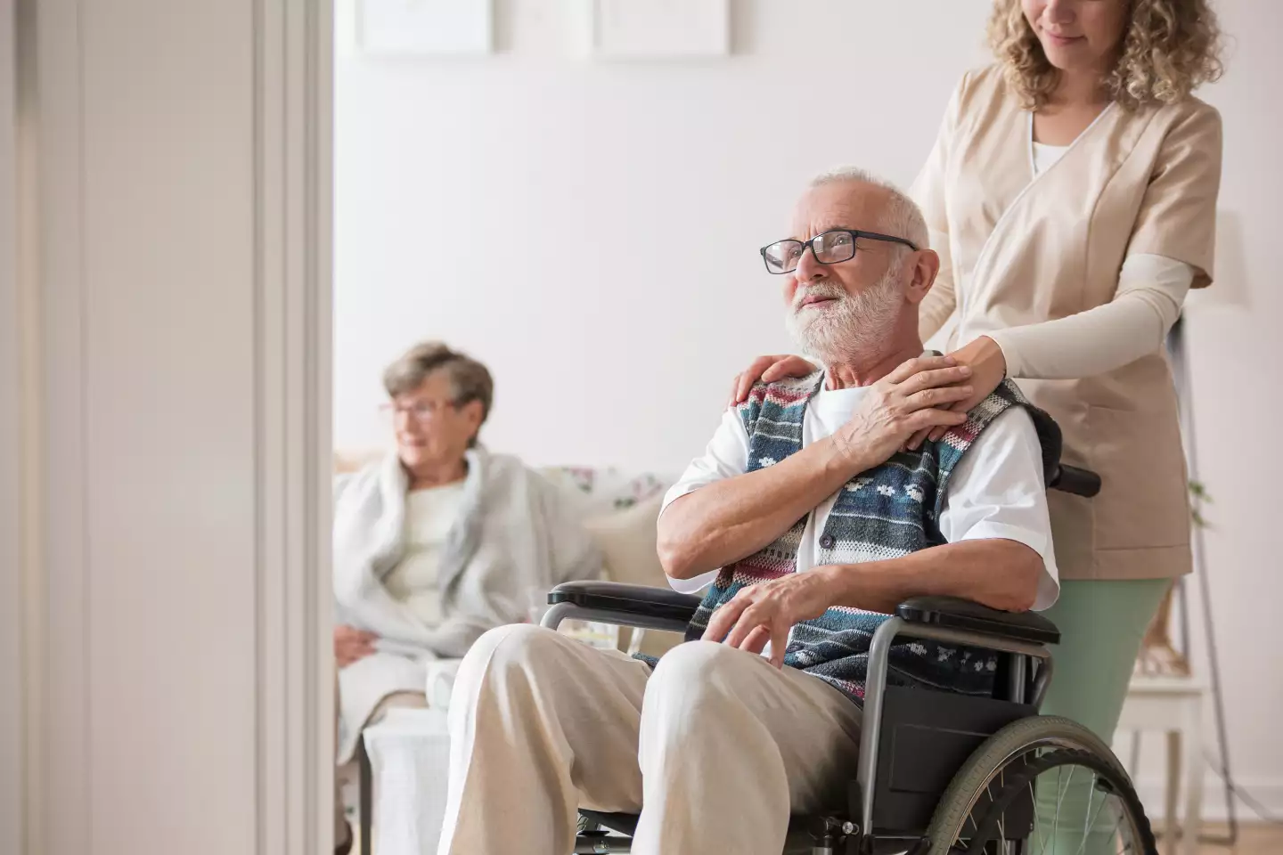 Eine Pflegerin legt ihre Hand auf die Schulter eines Bewohners